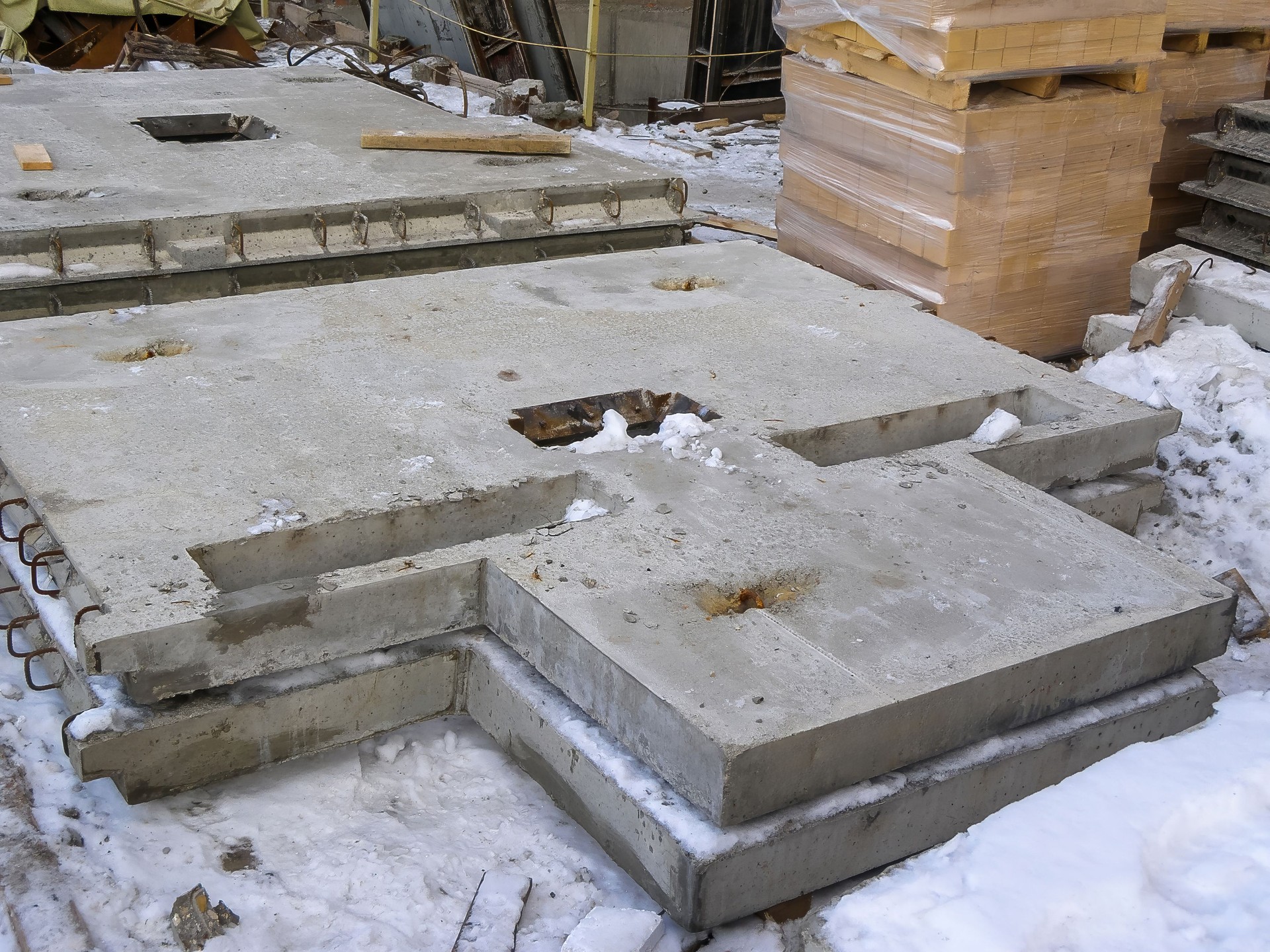 Concrete slabs stacked on a construction site, showcasing industrial and architectural materials. Concrete slabs stacked on a construction site, showcasing industrial and architectural materials.